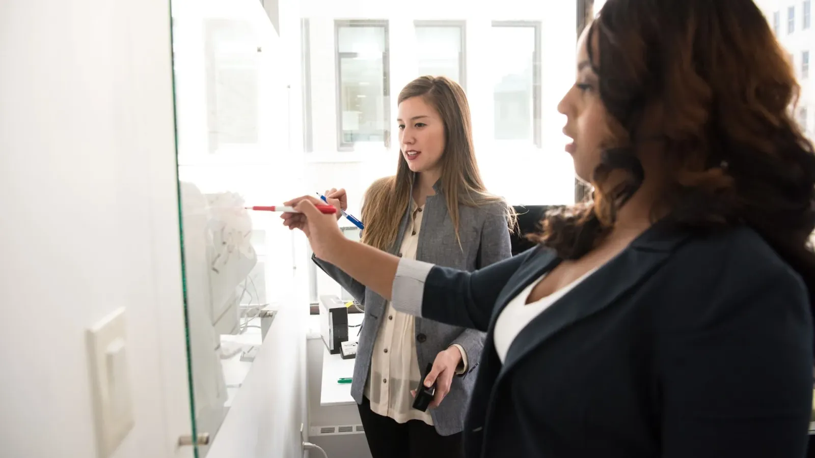 Business team mapping a process together on a whiteboard