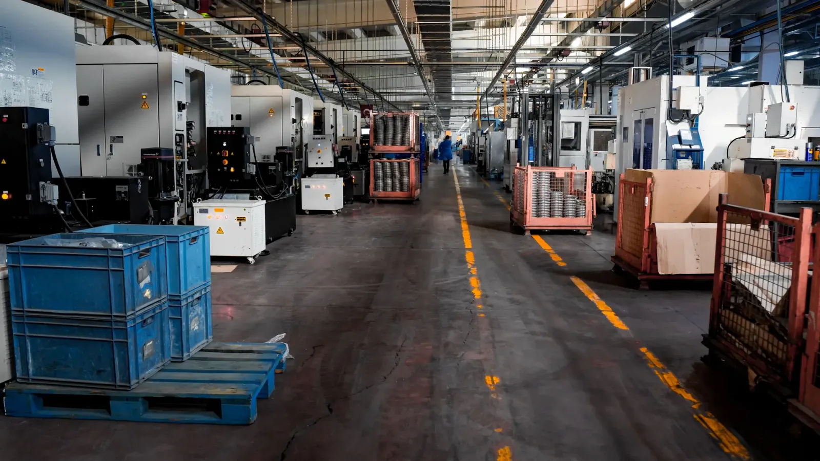 Modern manufacturing floor with production machinery, material containers and organized work areas