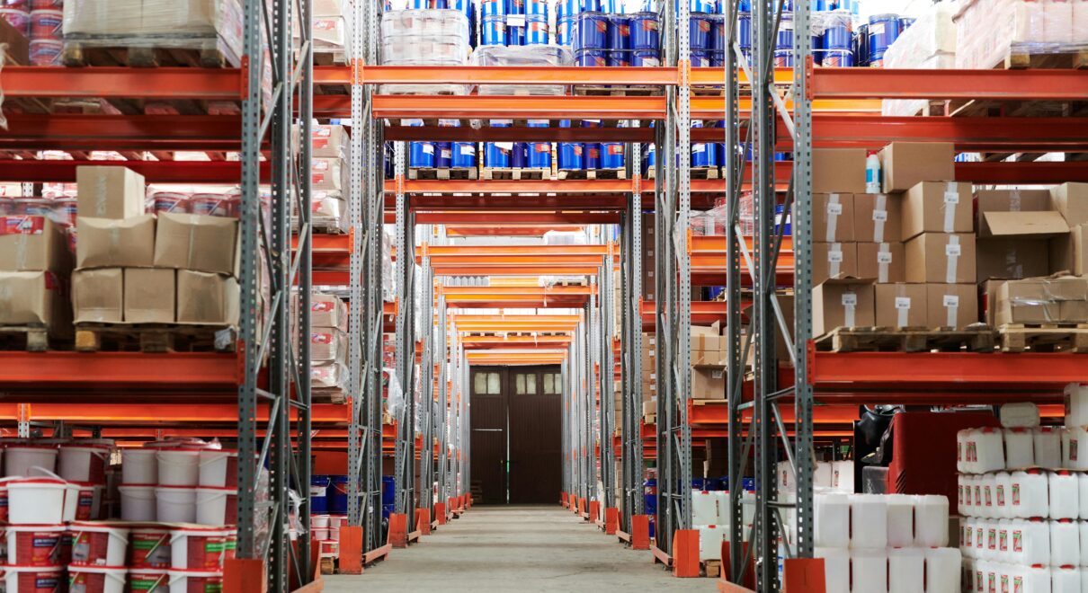 Wide angle view of a warehouse with stocked shelves and boxes.