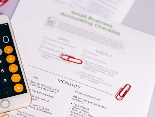 Image of a checklist and calculator for managing small business accounting tasks efficiently.