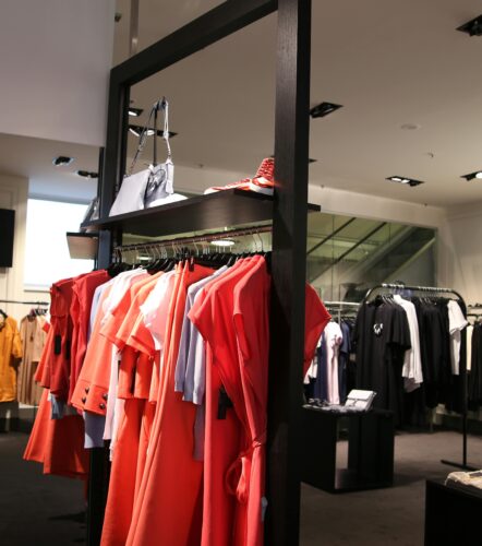 Discover a chic fashion boutique showcasing a variety of colorful clothes on elegant racks.