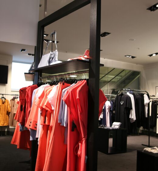 Discover a chic fashion boutique showcasing a variety of colorful clothes on elegant racks.